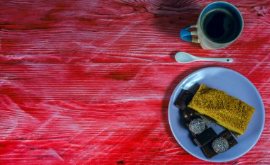 Bir kupa taze kahve, kırmızı ahşap arka planda..