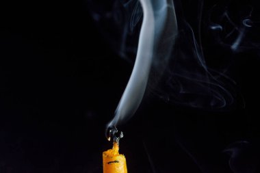 Karanlık bir arka planda sönen bir mumu tüttürmek.