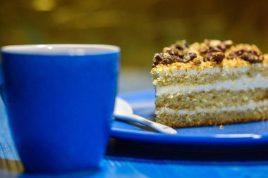 Cevizli bir dilim kek, bir fincan kahvenin yanında..