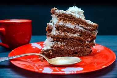 Kırmızı tabakta bir dilim lezzetli pasta ve D 'nin üzerinde taze kahve.