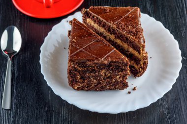 Bir tabak çikolatalı kek, bir fincan kahvenin yanında.