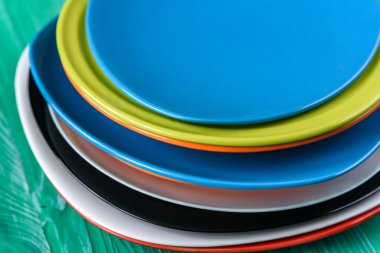 Ahşap arka planda bir yığın renkli tabak..