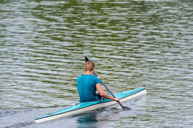 Bir adam kanoyla yelken açar.