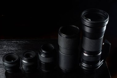Siyah ahşap arka planı olan telefoto lensleri