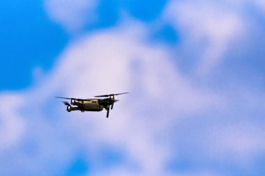 Mavi gökyüzünün arka planında bulutlu bir dron.