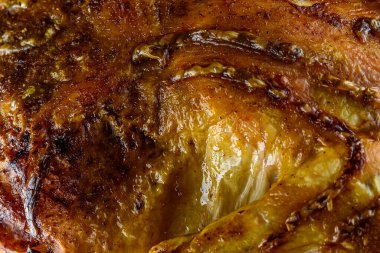 Kızarmış tavuk, ahşap bir arka planda beyaz bir tabakta.