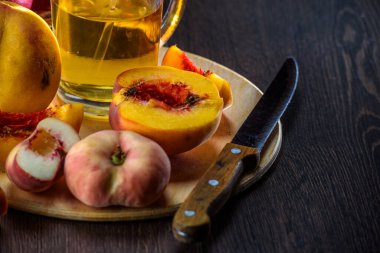 Karanlık bir arka planda şeftali ve meyve suyu dolu bir hayat