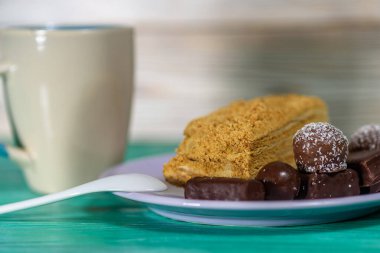 Ev yapımı hamur işleri ve çikolatalar seramik tabakta, ahşap bir arka planda..
