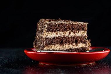 Bir parça çikolatalı kek ve üzerinde çikolata olan kurabiyeler.