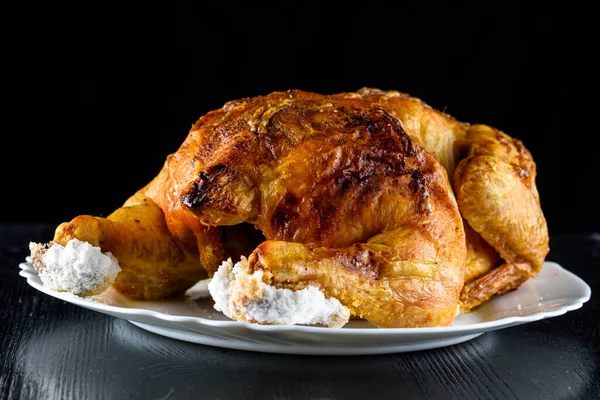 Kızarmış tavuk, ahşap bir arka planda beyaz bir tabakta.