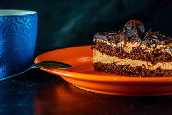Pedaço Bolo Chocolate Prato Laranja Lado Café Uma Xícara Azul — Fotografia de Stock