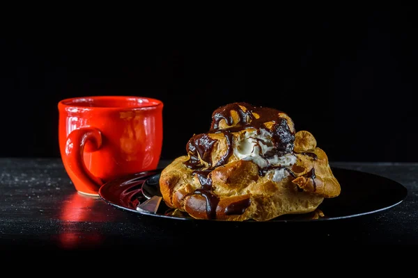 Éclair Chocolat Sur Une Assiette Noire Café Dans Une Tasse — Photo