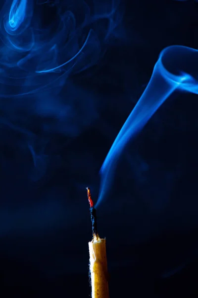 Smoke from an extinguished candle on a dark background.