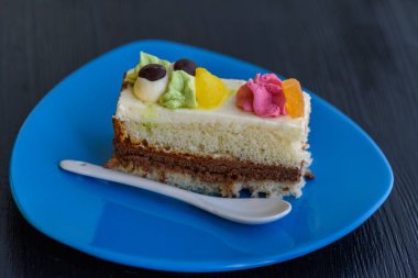 Kremalı pasta, ahşap bir arka planda mavi bir tabakta yakın plan fotoğrafı..