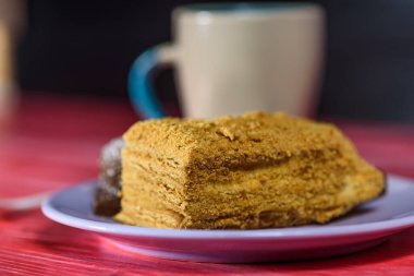 Tahta bir arka planda, bir tabakta duran sünger keki..