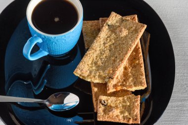 Tahta bir arka planda, bir fincan sade kahve ve kurabiye.