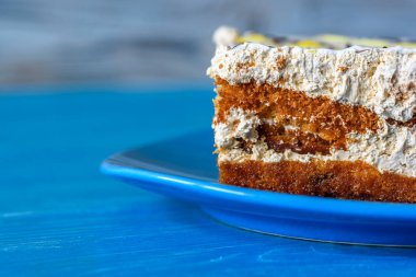 Tahta bir masadaki tabakta bir parça kek..