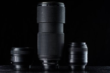 Siyah ahşap arka planı olan telefoto lensleri