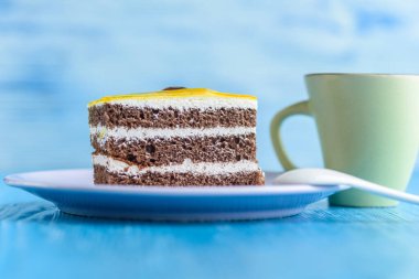 Üzerinde kiraz olan çikolatalı pasta ve tahta arka planda yakın plan çekilmiş bir fincan kahve..