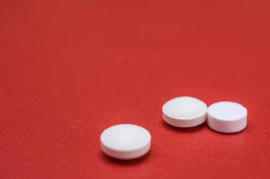 Kırmızı arkaplanda ilaç hapları