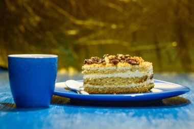 Cevizli bir dilim kek, bir fincan kahvenin yanında..