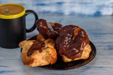 Ahşap arka planda kahve ve çikolata ekleriName