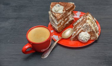 Kremalı ekşi pasta ve kırmızı bardakta taze kahve.