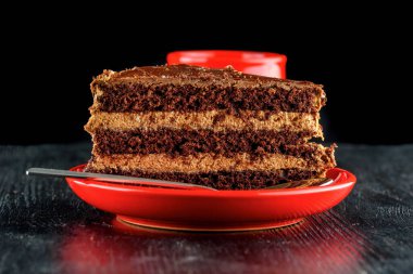 Bir parça çikolatalı kek ve üzerinde çikolata olan kurabiyeler.