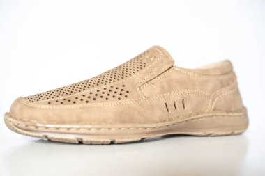 Erkek bej rengi deri ayakkabılar, model mokasenler. Işık arkaplanda yakın plan çekimleri.