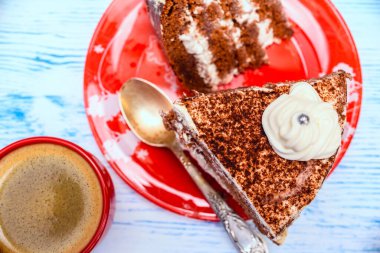 Kırmızı tabakta lezzetli bir kek ve hafif bir kahve.