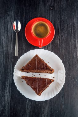 Bir tabak çikolatalı kek, bir fincan kahvenin yanında.