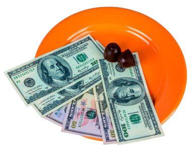 Turuncu bir tabağın üstünde çikolatalı şekerler ve nakit parayla.