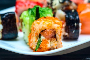 Beyaz bir tabakta suşi. Yakından çekilmiş..