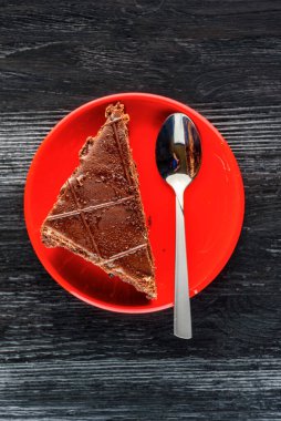 Bir parça çikolatalı kek ve üzerinde çikolata olan kurabiyeler.