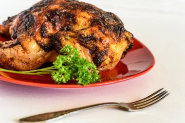 Kırmızı tabakta ızgara tavuk.