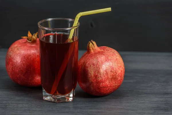 glass beaker with pomegranate juice and pomegranate fruits on a