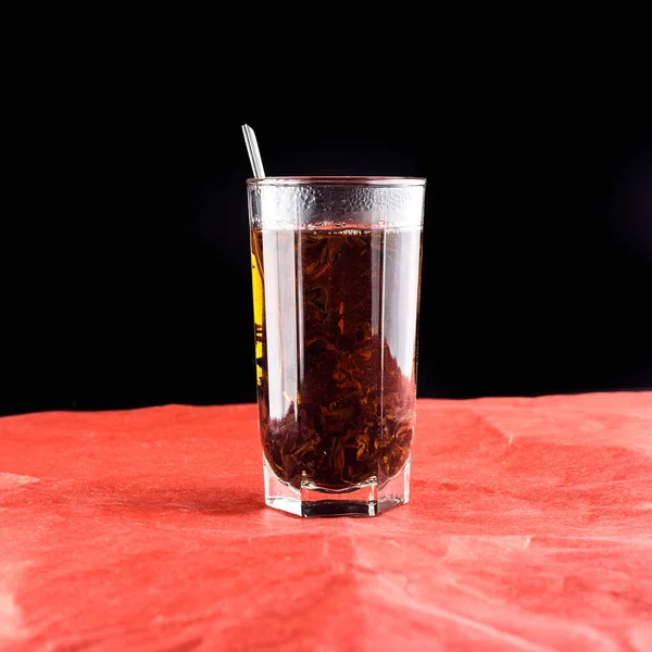 Szkło Szklane Herbatą Sfotografowane Bliska Czerwonym Papierze — Zdjęcie stockowe
