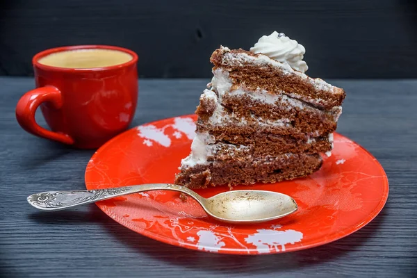 Kremalı ekşi pasta ve kırmızı bardakta taze kahve.