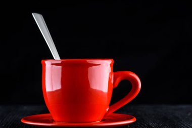 Siyah arka planda kırmızı bardakta nefis bir kahve.