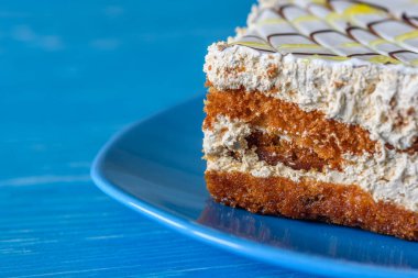 Tahta bir arka planda, bir tabakta duran sünger keki..