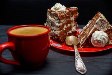 Kremalı ekşi pasta ve kırmızı bardakta taze kahve.