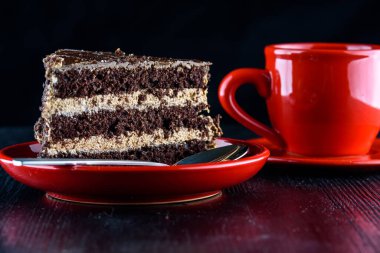 Bir tabak çikolatalı kek, bir fincan kahvenin yanında.