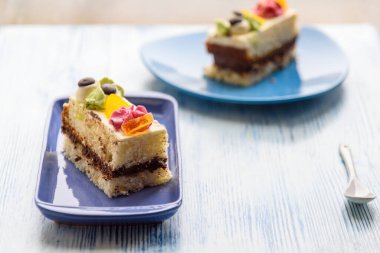 Kremalı pasta, ahşap bir arka planda mavi bir tabakta yakın plan fotoğrafı..