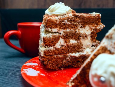 Kırmızı tabakta bir dilim lezzetli pasta ve D 'nin üzerinde taze kahve.