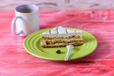 Tahta bir masadaki tabakta bir parça kek..