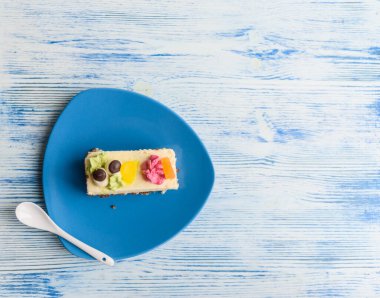 Kremalı pasta, ahşap bir arka planda mavi bir tabakta yakın plan fotoğrafı..