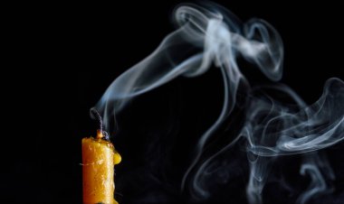 Siyah arka planda sönmüş bir mumun dumanı..