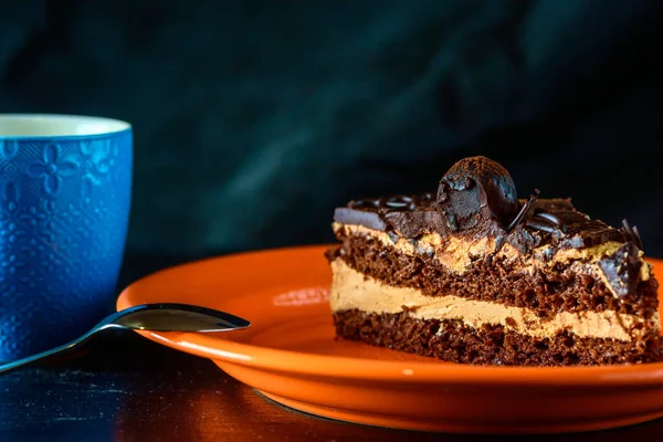 Pezzo Torta Cioccolato Piatto Arancia Accanto Caffè Una Tazza Blu — Foto Stock