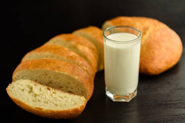 Ciabatta ve tahta arka planda bir bardak süt..
