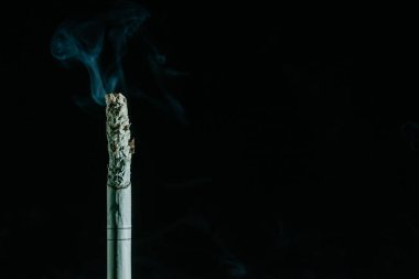 Siyah arka planda sigara içmek.
